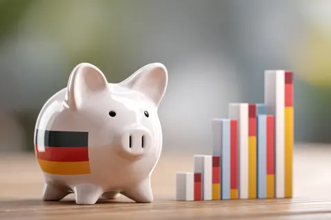 Economic Growth of Germany: A piggy bank adorned with German flag next to a rising bar graph, highlighting financial growth and the nation's economic 