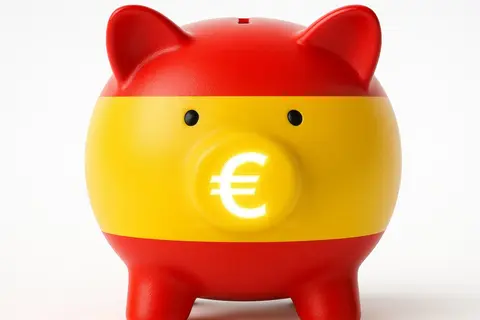 Piggy bank in Spanish flag colors with glowing euro symbol representing national savings, finance and European economy, isolated on white background -