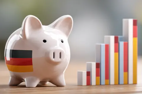 Economic Growth of Germany: A piggy bank adorned with German flag next to a rising bar graph, highlighting financial growth and the nation's economic 